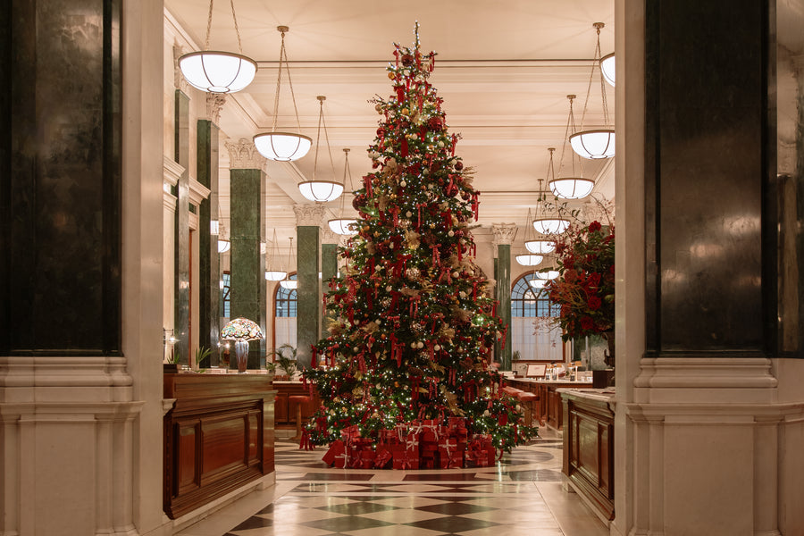 The full tree viewed from across The Ned's lobby, framed by green marble columns