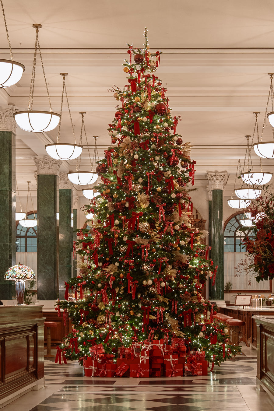 The lit tree as seen from the bar, with red leather stools in the foreground